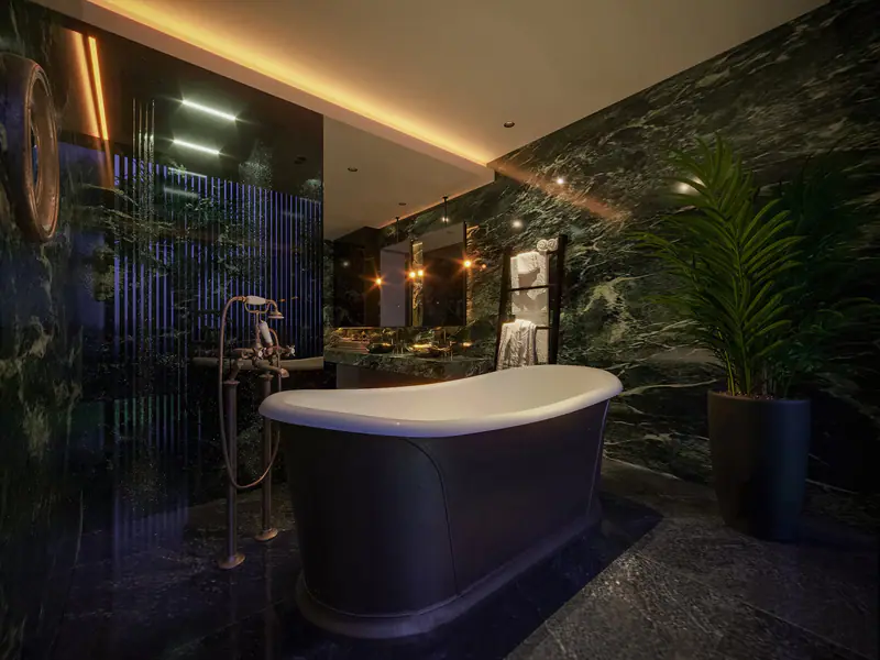 Bồn tắm đứng giữa phòng tắm đá xanh